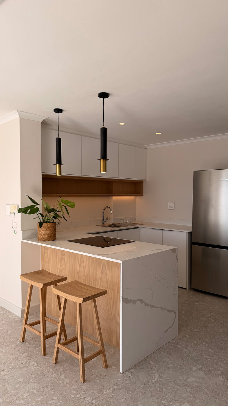 Open-plan kitchen with a marble island and bar stools in the Cape Town apartment