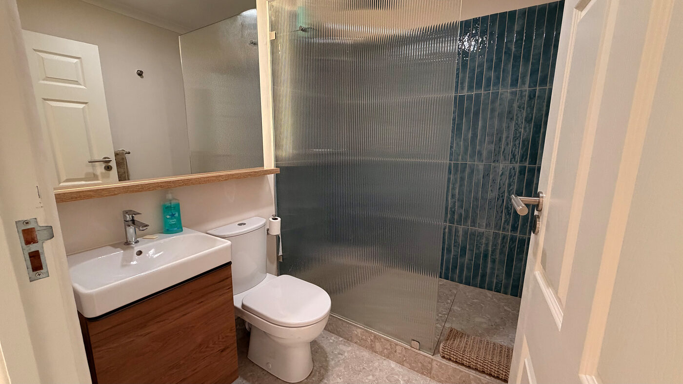 Bathroom with a walk-in shower, vanity and tiled finishes