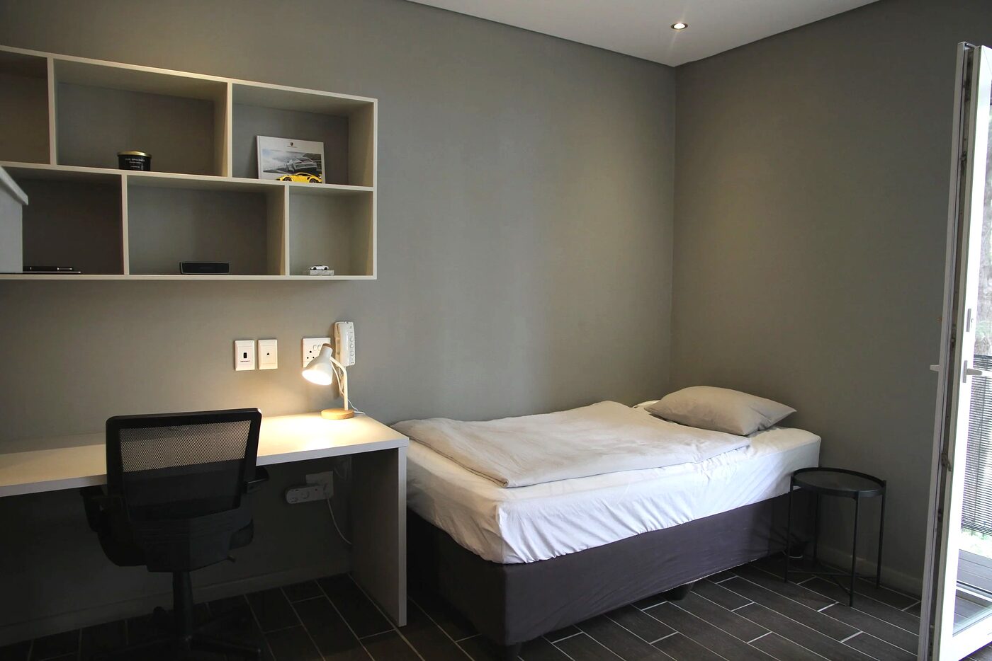 Student bedroom with a single bed, study desk and built-in shelving in Stellenbosch